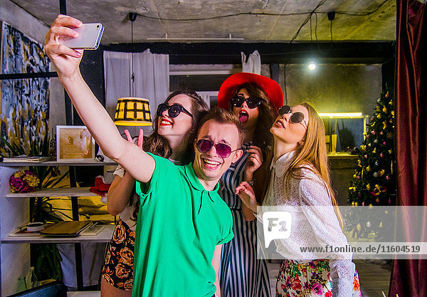 Modische kaukasische Freunde  die für ein Handy-Selfie posieren