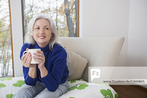 Portrait of smiling Caucasian woman drinking coffee