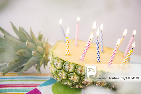 Candles burning in half of sliced pineapple