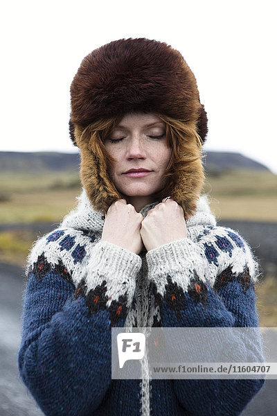 Caucasian woman wearing sweater and fur hat