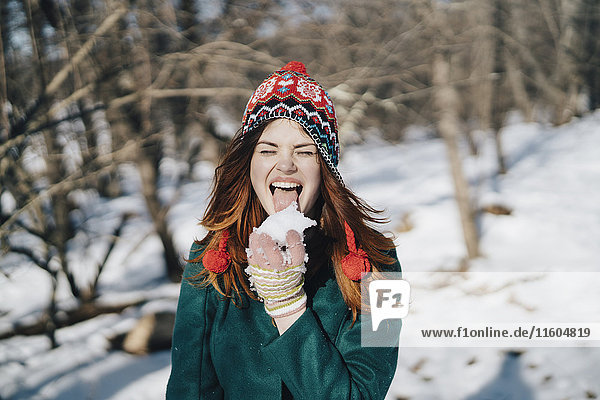 Caucasian woman licking snow