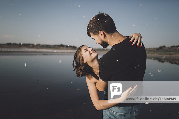 Caucasian couple hugging at lake