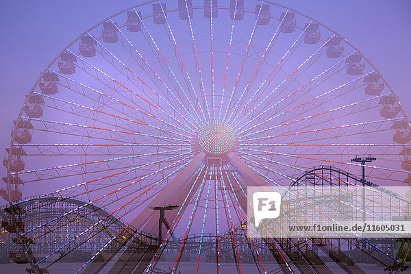 Double exposure of ferris wheel and roller coaster
