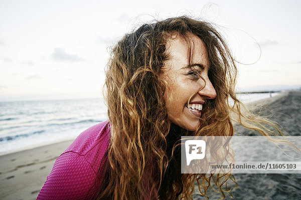 Wind weht Haare der kaukasischen Frau am Strand