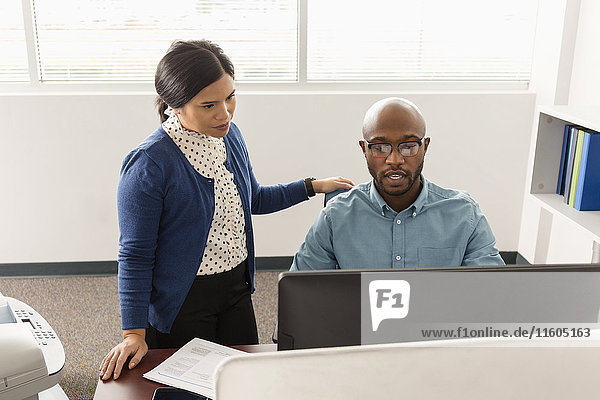 Man and woman working at computer in office