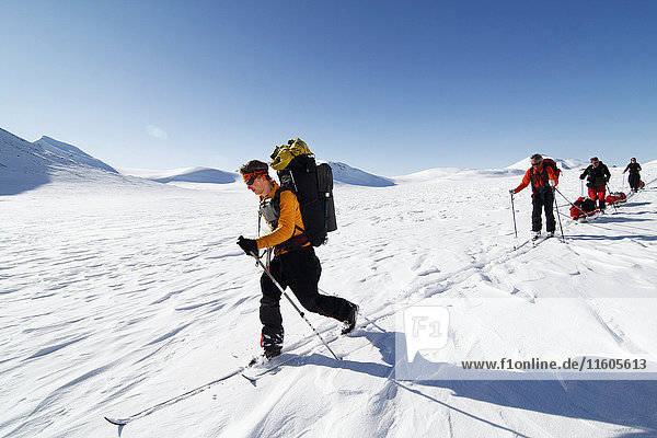 Tourists cross country skiing in mountain scenery