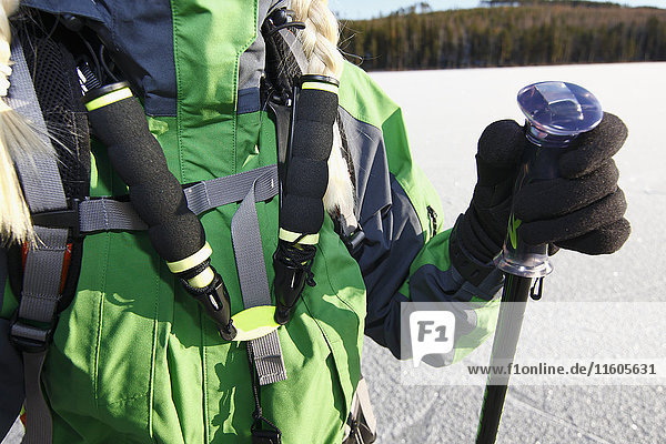 Mid section of woman holding ski poles
