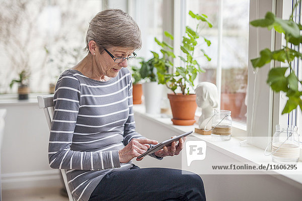 Ältere Frau benutzt digitales Tablet