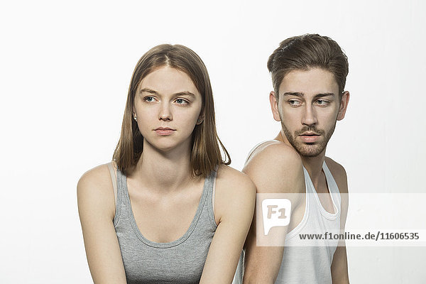 Man looking at upset woman against white background