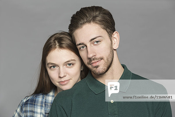 Porträt eines lächelnden Paares vor grauem Hintergrund