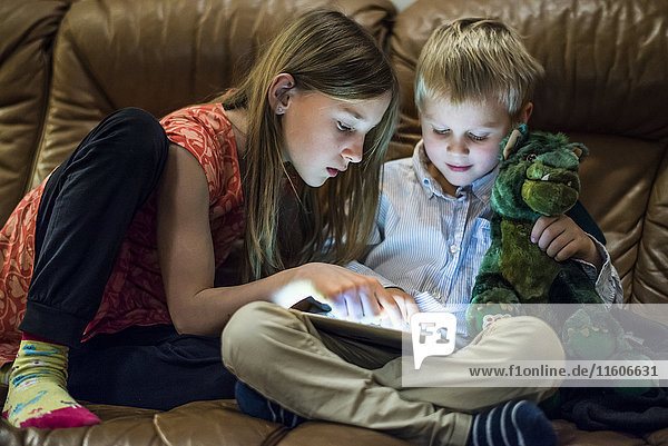 Bruder und Schwester benutzen ein digitales Tablet