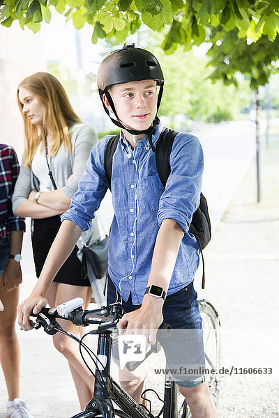 Jugendliche mit Fahrrädern zu Fuß in der Stadt