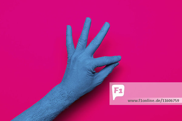 Nahaufnahme des blau gestrichenen Handzeichens auf rosa Hintergrund