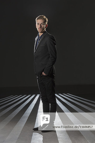 Portrait of businessman wearing formals standing against black background