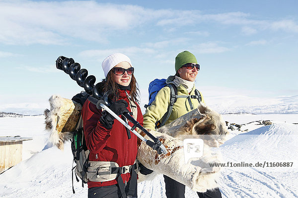 Women with ice fishing equipment