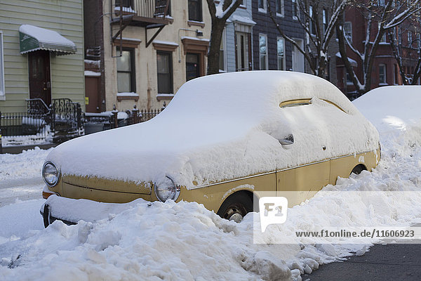 Schneebedecktes Auto auf der Straße in der Stadt