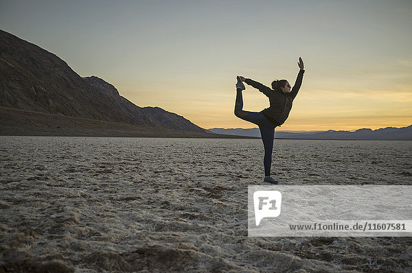 Volle Länge der jungen Frau beim Yoga in der Wüste bei Sonnenuntergang  Death Valley  Nevada  USA