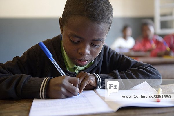 Student  boy writing  12 years  Primary School  Fianarantsoa  Madagascar  Africa