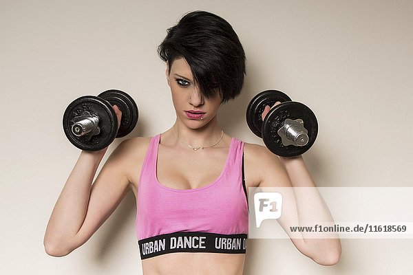 Young woman during fitness workout  lifting weights  sports  portrait