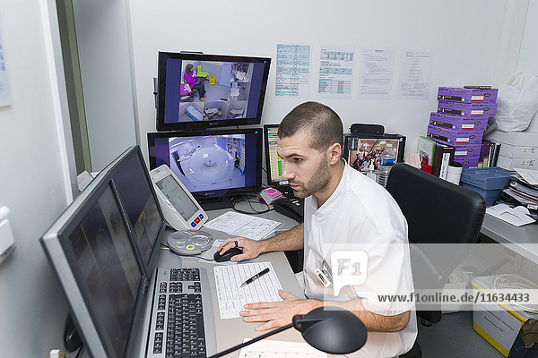 Reportage on PET imaging at the Antoine-Lacassagne Cancer centre in Nice  France. Positron Emission Tomography  or PET scan  is used in diagnosing and monitoring patients with cancer. This method enables tumours to be detected using a radioactive tracer  which accumulates heavily in cells that present a pathological hypermetabolism. The technician checks results of past exams.