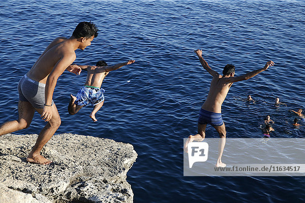 Junge Männer springen ins Mittelmeer.