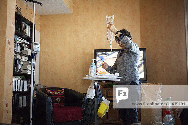 Reportage on a home health care service in Savoie  France. A nurse changes a patient with cancer’s chemotherapy drip.