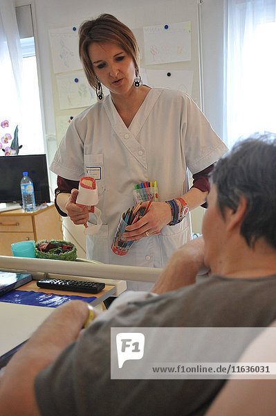 Reportage on art therapy in Ham hospital’s long-stay unit  France. Art therapy sessions are offered to residents in order to maintain or rehabilitate their motor  cognitive and sensory functions as well as social ties. The art therapist attaches great importance to self-esteem. She considers that touch  contact and considerate gestures are vital for the success of the workshops.