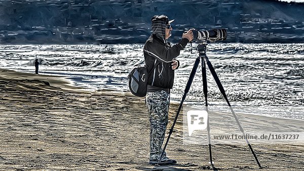 Photographer Aiming Camera with Telephoto Lens at Beach