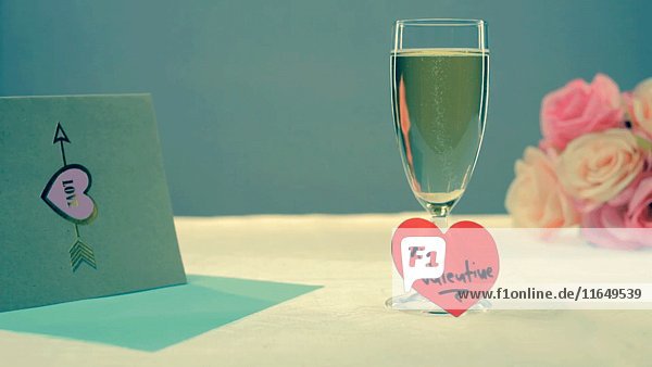 Glas Champagner mit Valentine Heart Message  Karte und Blumen auf dem Tisch