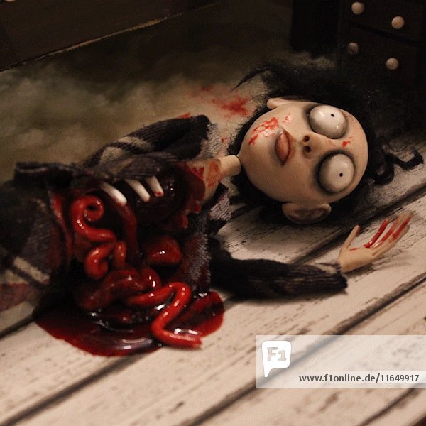 Groteske Puppenfigur eines sterbenden Mannes  der auf dem Boden blutet  Stop-Motion-Effekt