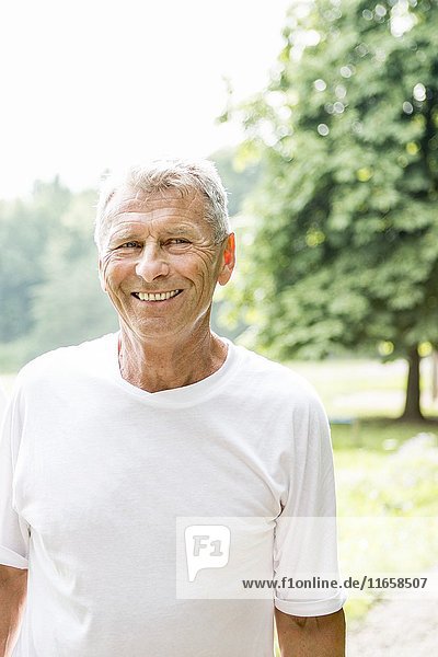 Senior man in white t-shirt smiling  portrait.