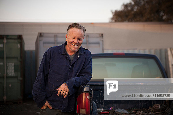 Man leaning against truck smiling