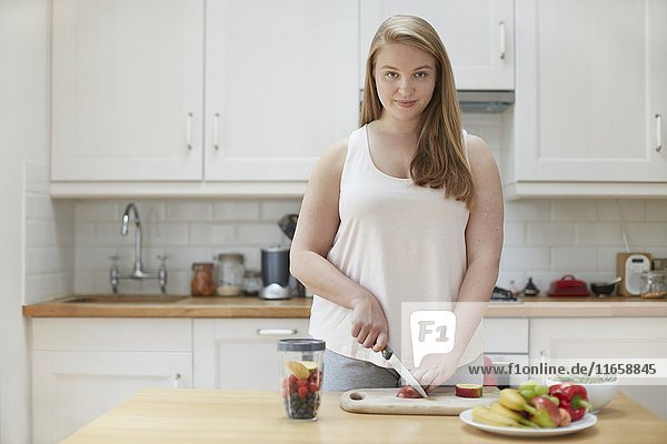 Young woman preparing healthy food in kitchen.