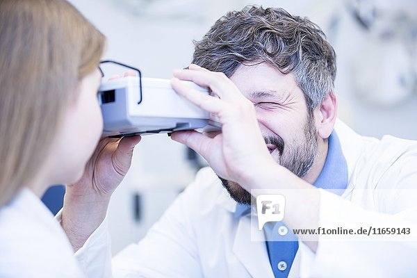 Ein Optiker führt einen Sehtest bei einem jungen Mädchen durch.