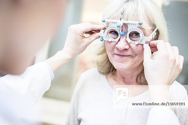 Senior woman having eye exam by optometrist.