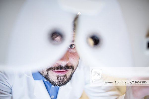 Optometrist,  der einen Sehtest in einem Optikergeschäft durchführt,  Nahaufnahme.