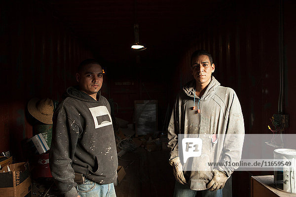 Porträt von Bauarbeitern in Schiffscontainer mit Blick in die Kamera