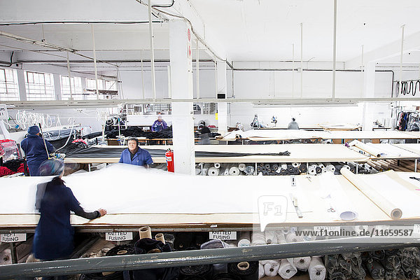 Fabrikarbeiterinnen rollen Textilien in Bekleidungsfabrik ab