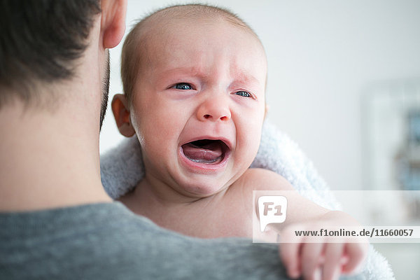 Über-Schulter-Ansicht eines Mannes  der ein weinendes Baby trägt