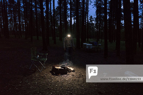 Man with headlamp cooking on campfire  South Dakota  USA
