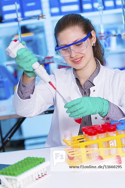 Eine Wissenschaftlerin benutzt eine Pipette im Labor.