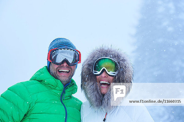 Porträt eines glücklichen  reifen Paares im Schneefall  Gstaad  Schweiz