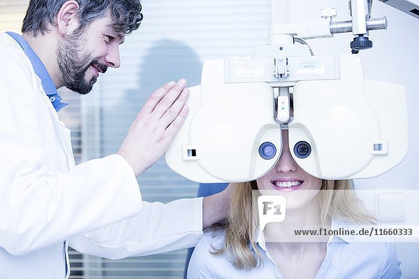 Junge Frau bei einer Augenuntersuchung durch einen Optiker.