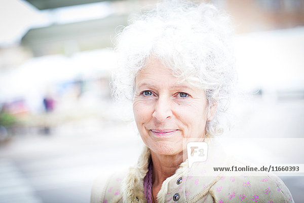Porträt einer grauhaarigen  reifen Frau auf einem lokalen französischen Markt