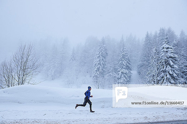 Fernansicht eines männlichen Läufers  der im Tiefschnee läuft  Gstaad  Schweiz