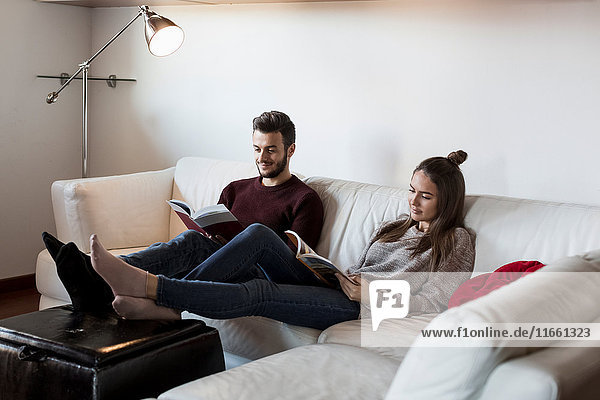 Young couple  relaxing on sofa  reading magazines