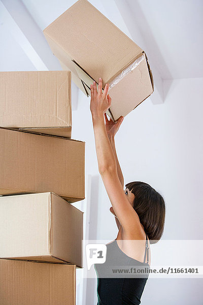 Woman stacking packing boxes