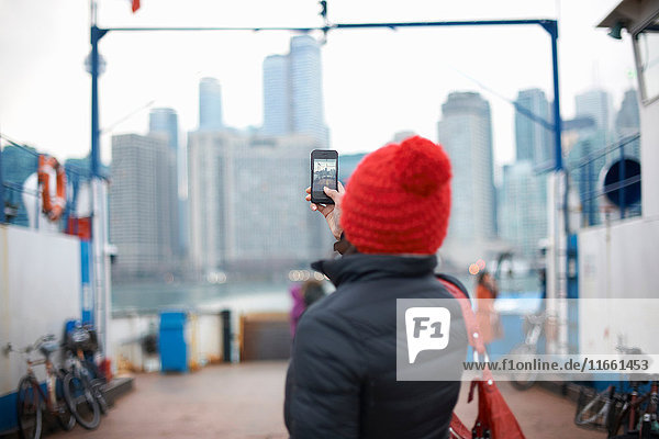 Frau fotografiert Skyline mit Smartphone  Toronto  Kanada