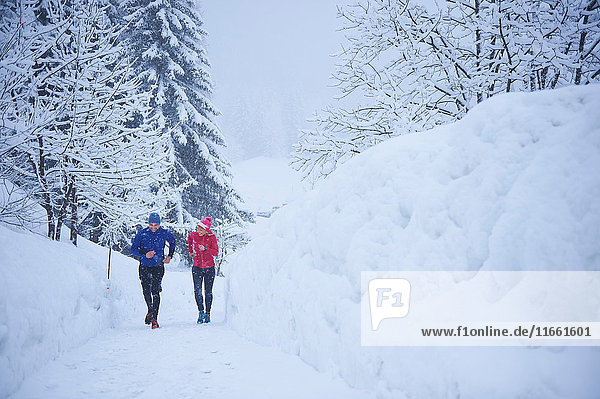 Male and female runners running on track in deep snow  Gstaad  Switzerland