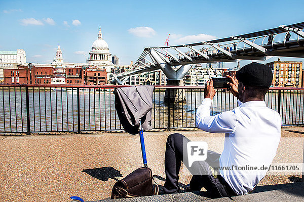 Businessman with scooter photographing St Paul's Cathedral  London  UK
